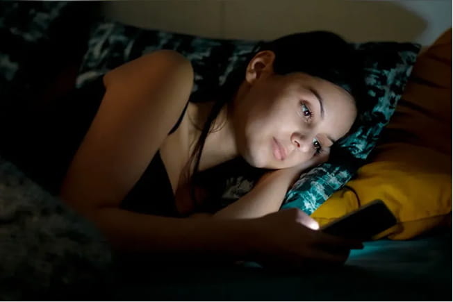 Mano sosteniendo una taza de cacao sobre la cama
